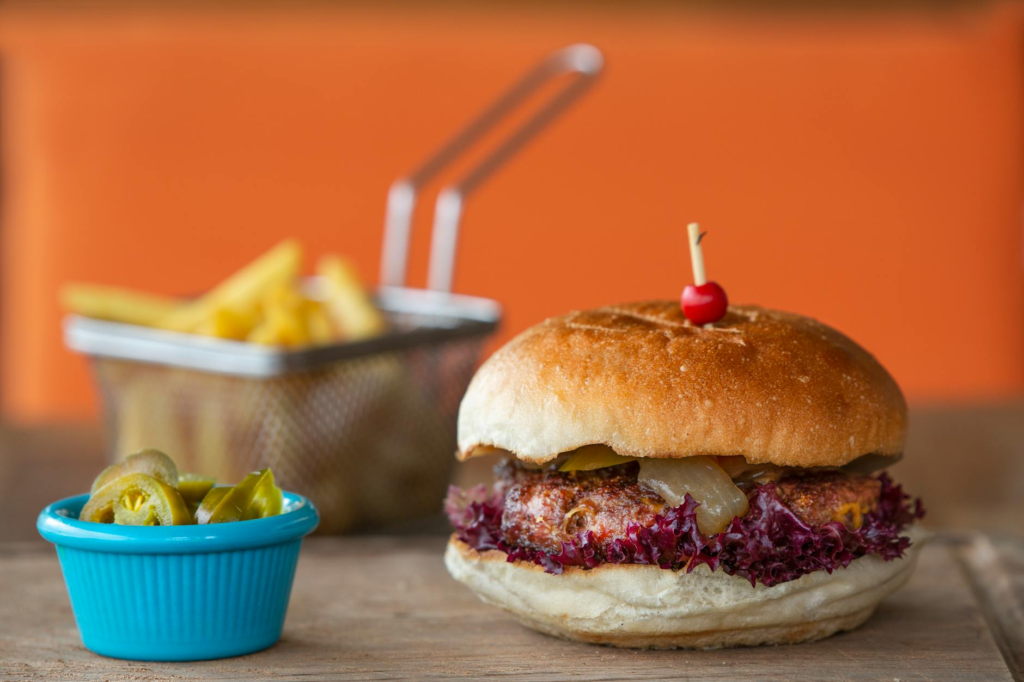 A Jingle Bell Jalapeno Burger with vibrant jalapeno slices. — Holiday Celebration Burgers Las Vegas