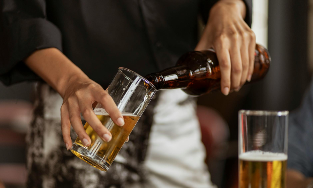 A bartender pouring a craft beer to pair with cheeseburger sliders. — culinary scene cheeseburger sliders Las Vegas
