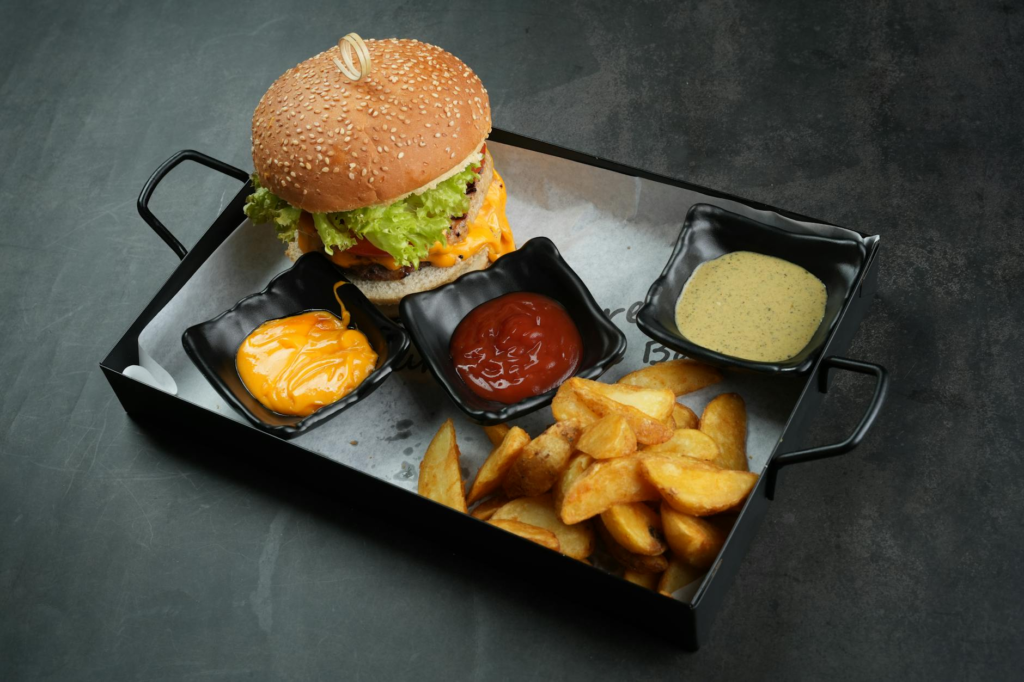 A beautifully plated cheeseburger slider with toppings and sides ready to serve. — family cooking cheeseburger sliders
