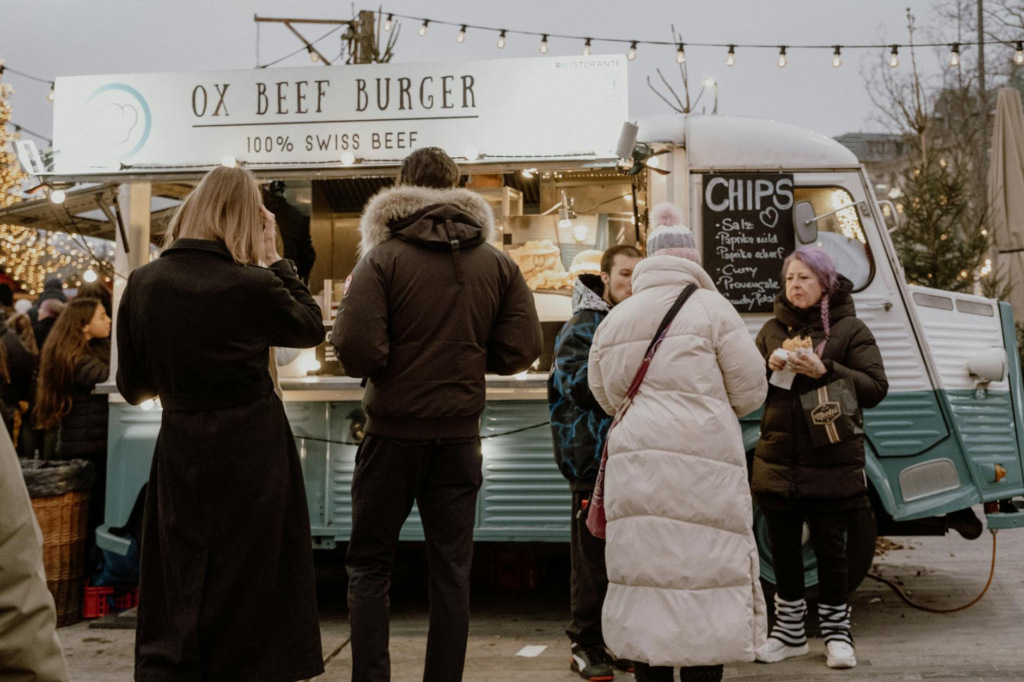 A bustling Las Vegas food truck event filled with happy customers enjoying Holiday Burger Food Trucks Las Vegas