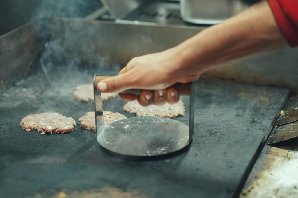 A chef grilling fresh patties in a vibrant kitchen — best burgers Las Vegas locals