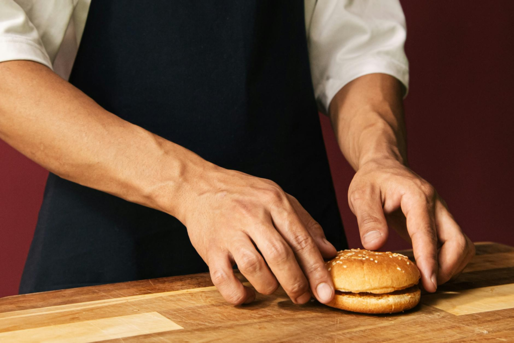 A chef preparing a fusion burger with holiday-themed ingredients. — Cultural Influences Holiday Burgers Las Vegas