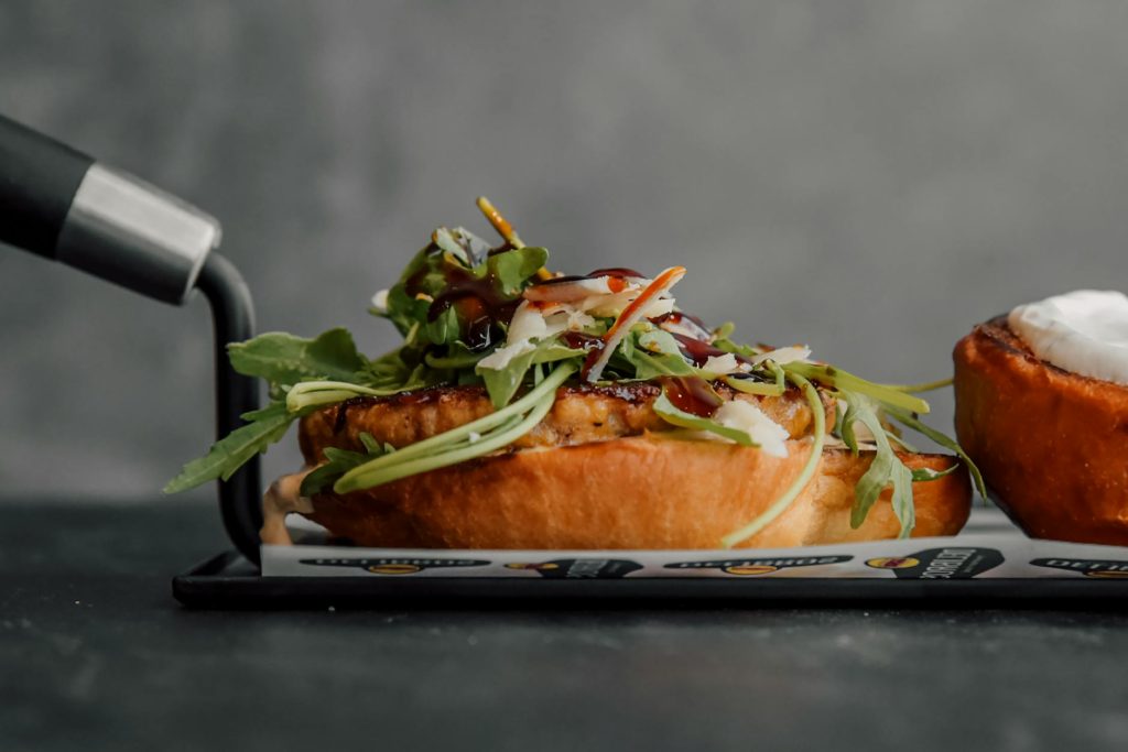 A close-up of a gourmet burger topped with truffle oil and arugula. — gourmet burgers Las Vegas