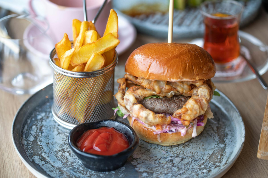 A close-up of a gourmet burger with a side of fries, emphasizing its presentation — celebrity chef burgers Las Vegas