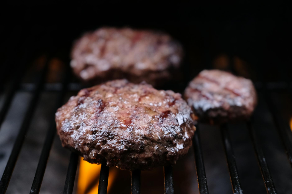 A close-up of a juicy burger being grilled on a barbecue. — gourmet burgers Las Vegas
