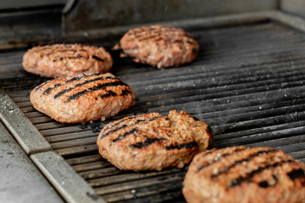 A close-up of a juicy burger being grilled, showcasing its perfect sear. — juiciest burgers Las Vegas