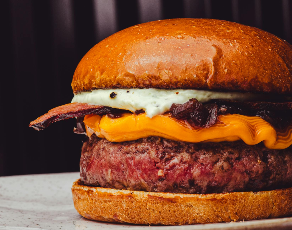 A close-up of a juicy plant-based burger, highlighting its toppings and textures. — vegan burgers Las Vegas
