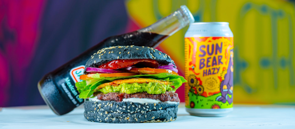A close-up of a restaurant's seasonal drink pairing with a holiday burger, highlighting vibrant colors. — Holiday Burger…