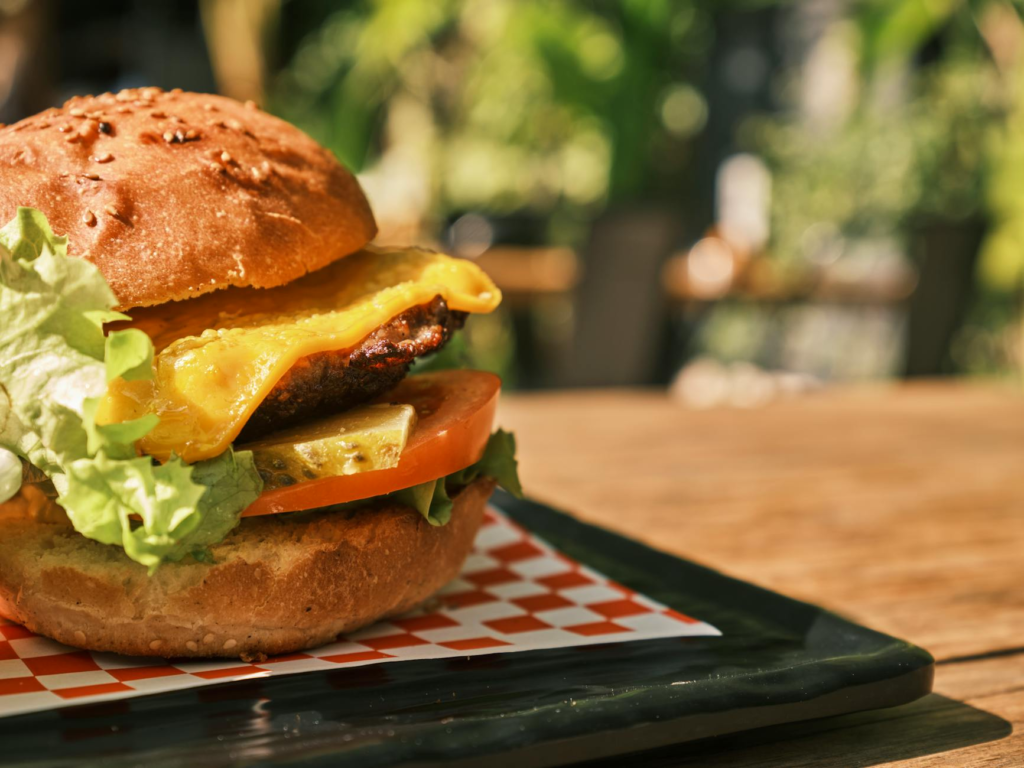 A close-up shot of a plate of cheeseburger sliders with melted cheese and pickles. — cheeseburger sliders Las Vegas Strip