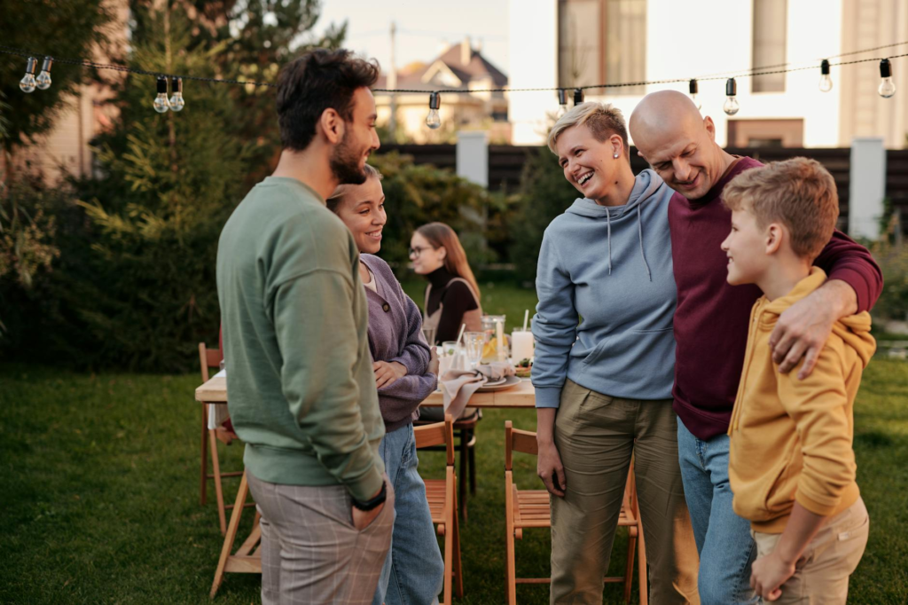 A family enjoying cheeseburger sliders together at a backyard gathering — cheeseburger slider bar