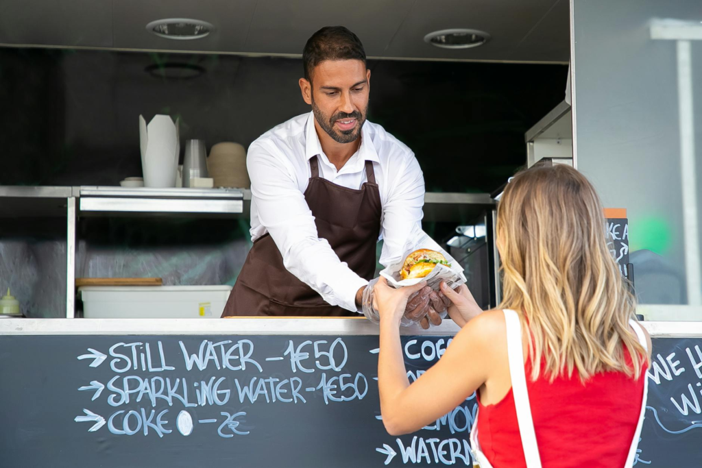 A food truck owner preparing burgers with holiday flair — Holiday Burger Food Trucks Las Vegas