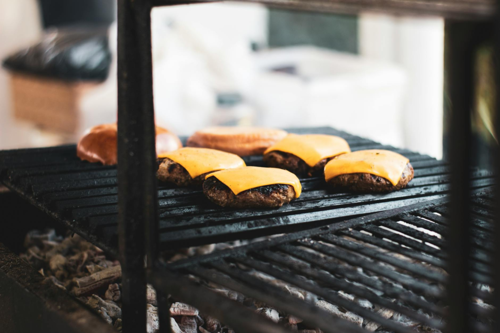 A grill with cheeseburger sliders sizzling, showcasing the cooking process. — cheeseburger sliders tailgating