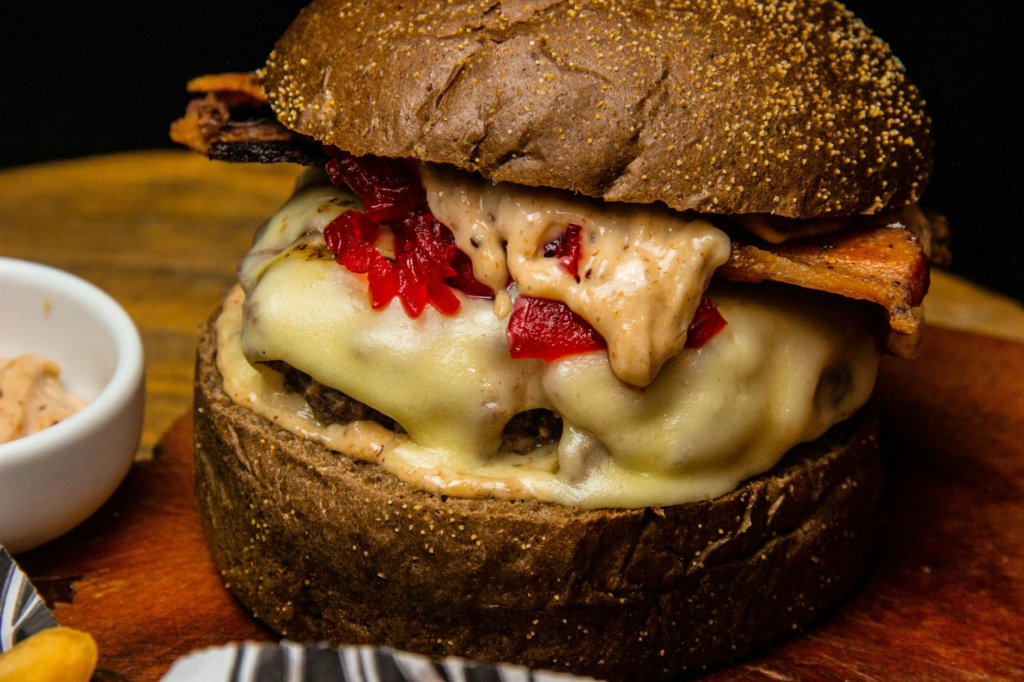 A mouth-watering close-up of a gourmet burger with toppings and sauces. — best burgers in Las Vegas
