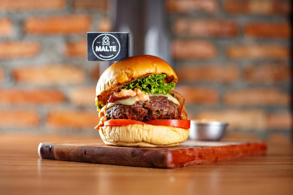 A mouth-watering gourmet burger from a local joint, highlighting fresh ingredients and unique toppings. — fast food vs l…