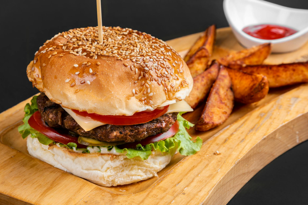 A side-by-side comparison of a fast food burger and a local burger, emphasizing the differences in size and presentation. …