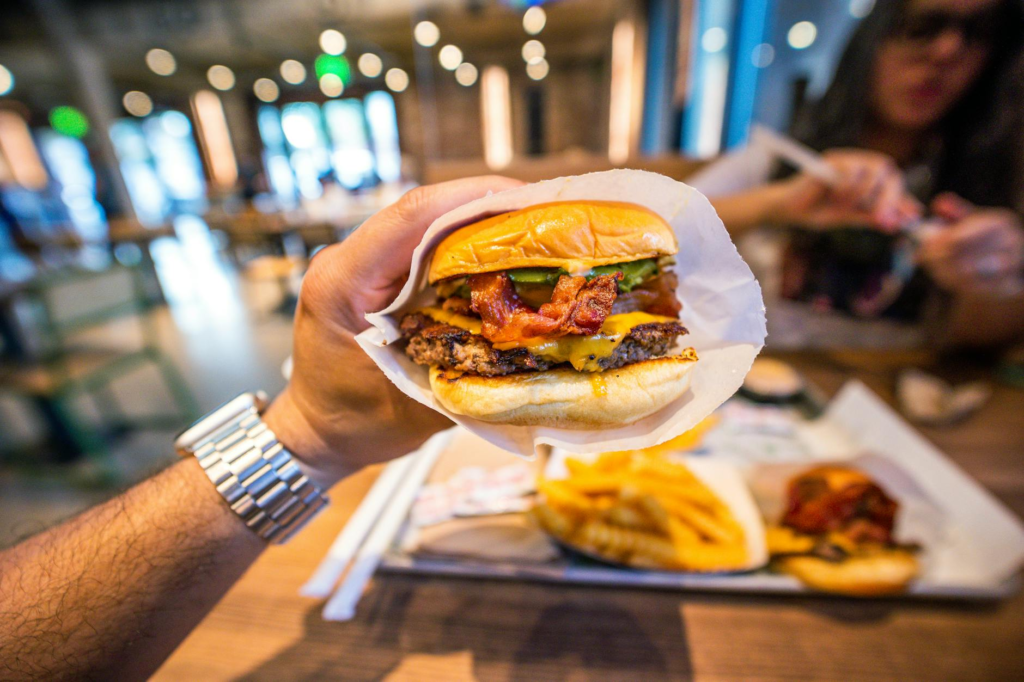 A smiling child with a big burger at a popular burger joint — family-friendly burgers Las Vegas