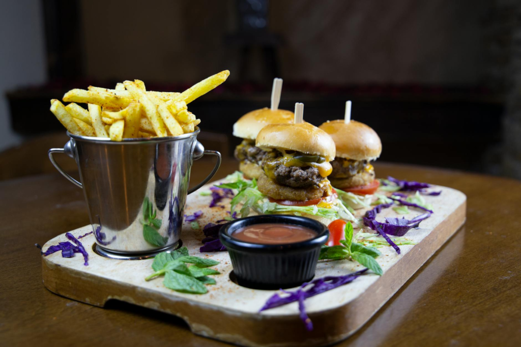 A tempting cheeseburger slider platter with various toppings and sauces. — cheeseburger slider deals Las Vegas