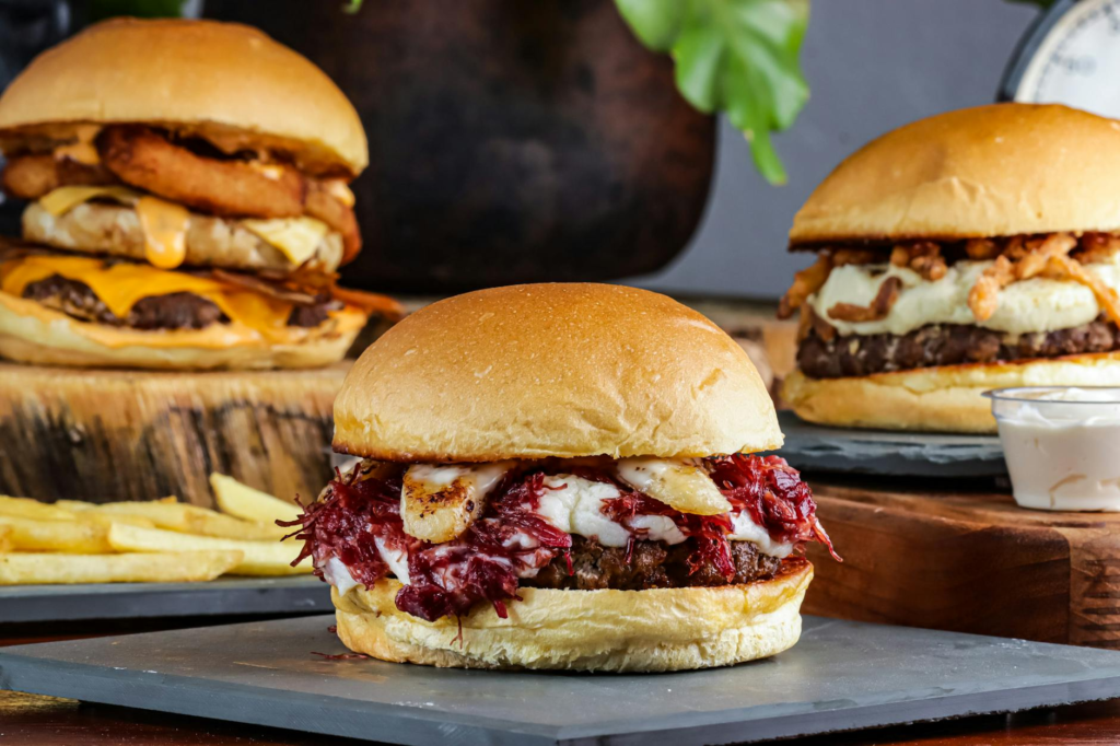 A vibrant platter of various gourmet burgers side by side, showcasing different styles and toppings. — gourmet burgers L…
