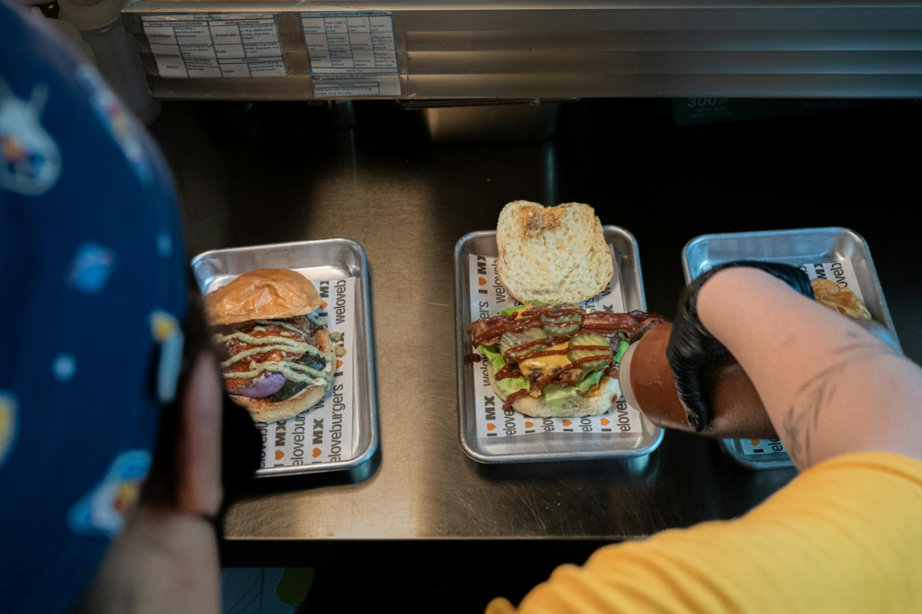 An array of different plant-based burgers served on colorful plates at a popular Las Vegas restaurant — vegan burgers La…