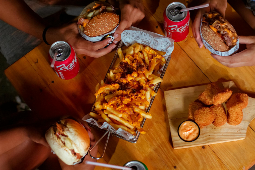 An overhead view of a table filled with various trendy burgers and drinks, showcasing a festive atmosphere. — Instagramm…