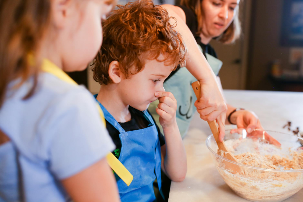 Kids and parents cleaning up together after a fun cooking session with family cooking cheeseburger sliders.