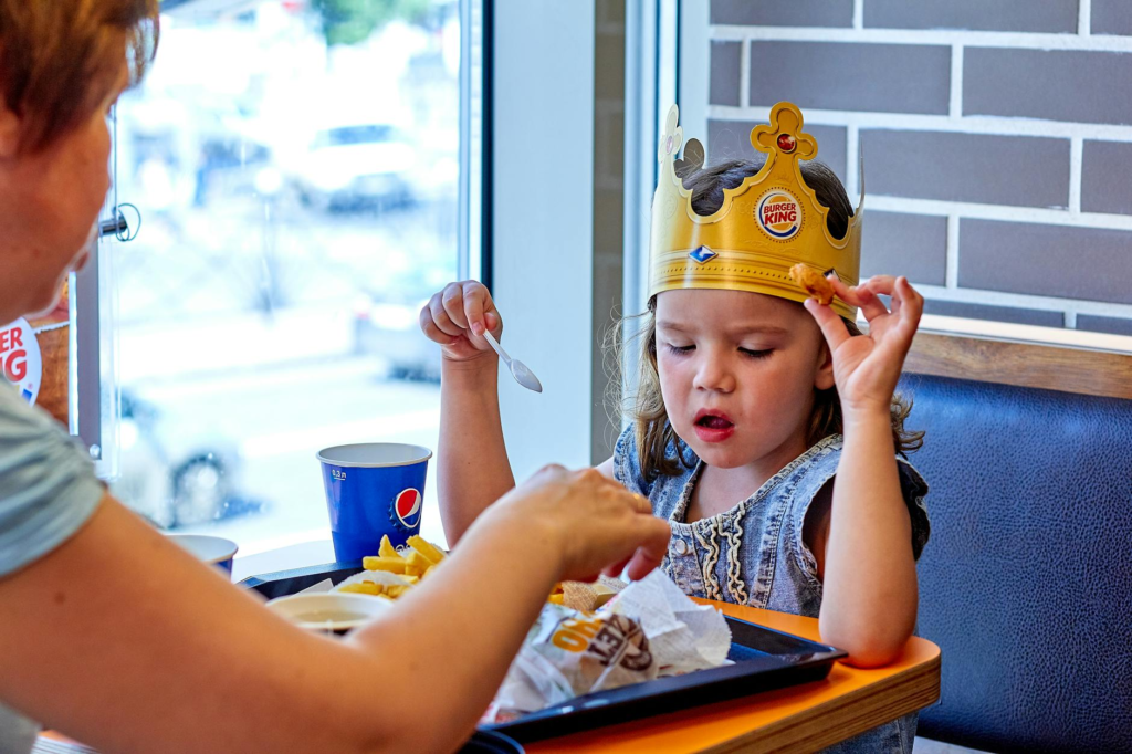 Kids smiling while holding their burgers in a family-friendly dining setting — family-friendly burgers Las Vegas