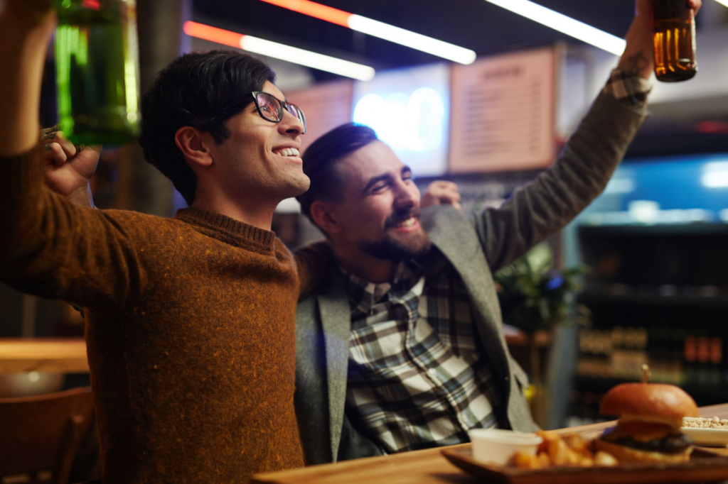 A cheerful group of friends enjoying burgers and drinks during happy hour at a Las Vegas restaurant. — burger deals Las …