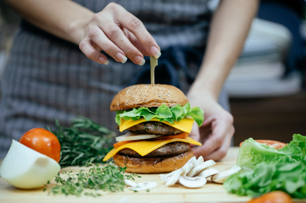 A chef preparing a Portobello mushroom burger in the kitchen, highlighting the fresh ingredients used. — vegan burgers L…