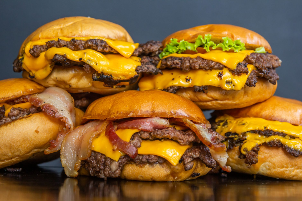 A classic Shake Shack burger with melted cheese and fresh toppings against a bustling Las Vegas backdrop. — gourmet burg…