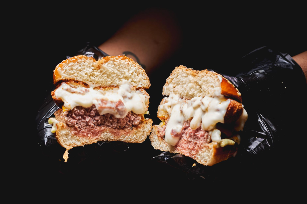 A close-up of a gourmet burger cut in half, displaying its juicy interior and toppings. — gourmet burgers Las Vegas