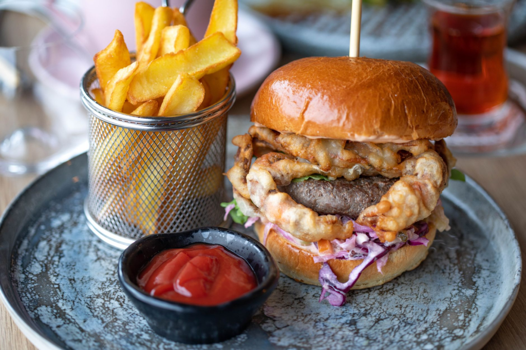 A close-up of an overpriced burger with a side of fries, highlighting the excessive price tag. — tourist trap restaurant…
