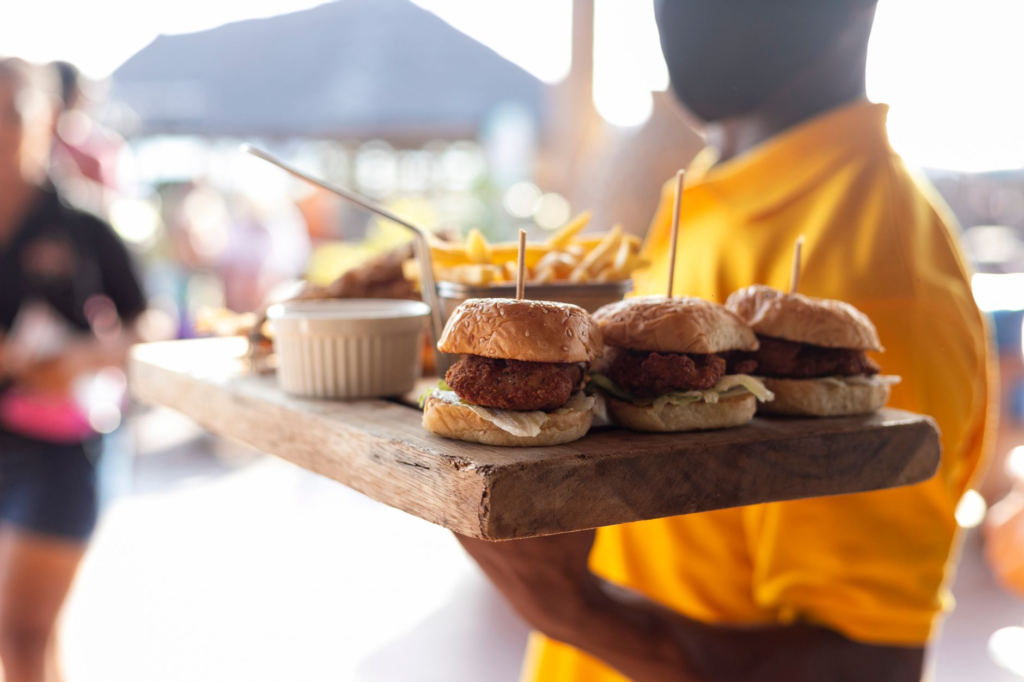 A close-up shot of a gourmet burger being served on a patio in Las Vegas with a sunny backdrop. — burger restaurants out…
