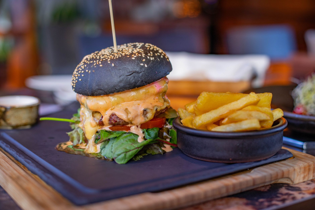 A close-up shot of a spicy burger with melted cheese and a side of fries, showcasing the vibrant colors. — spicy burgers…