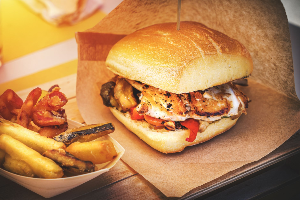 A delicious chicken burger with fresh toppings and crispy fries on a wooden table. — chicken burgers las vegas