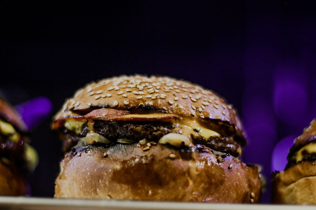 A mouth-watering close-up of a gourmet late night burger with toppings. — late night burgers Las Vegas