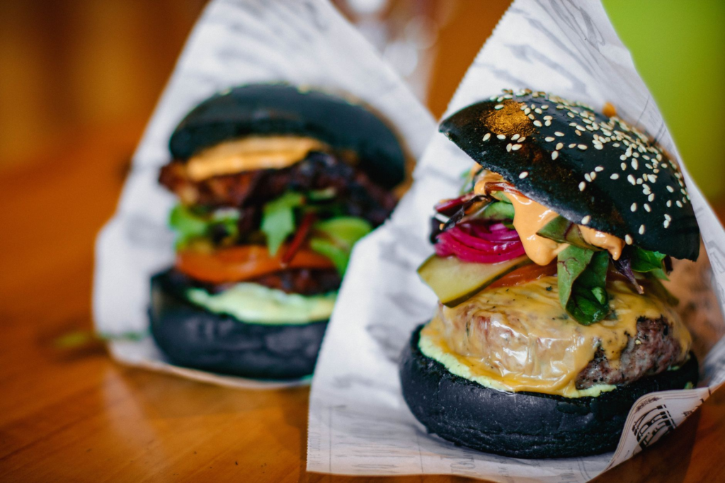 A mouth-watering gourmet burger with truffle and arugula on a rustic wooden table — best gourmet burgers Las Vegas