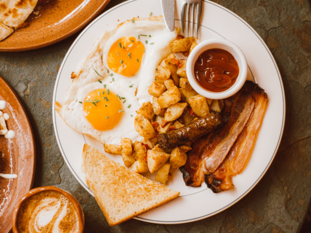 A mouthwatering breakfast burger with a sunny-side-up egg on top, served with crispy hash browns. — breakfast burgers la…