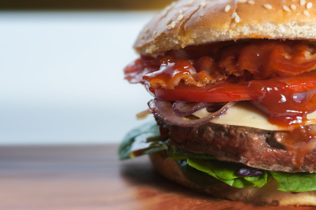 A mouthwatering close-up of a gourmet burger from Burger Bar, showcasing its juicy patty and fresh toppings. — best burg…
