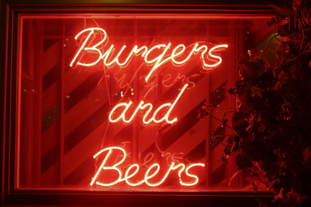 A neon-lit sign showcasing burger specials outside a Las Vegas restaurant. — burger deals Las Vegas