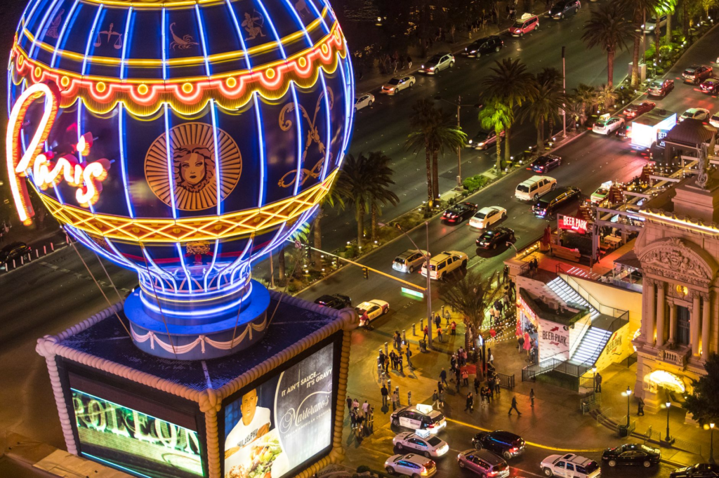 A picturesque view of the Las Vegas Strip at night, with bright lights and bustling crowds. — juiciest burgers Las Vegas…