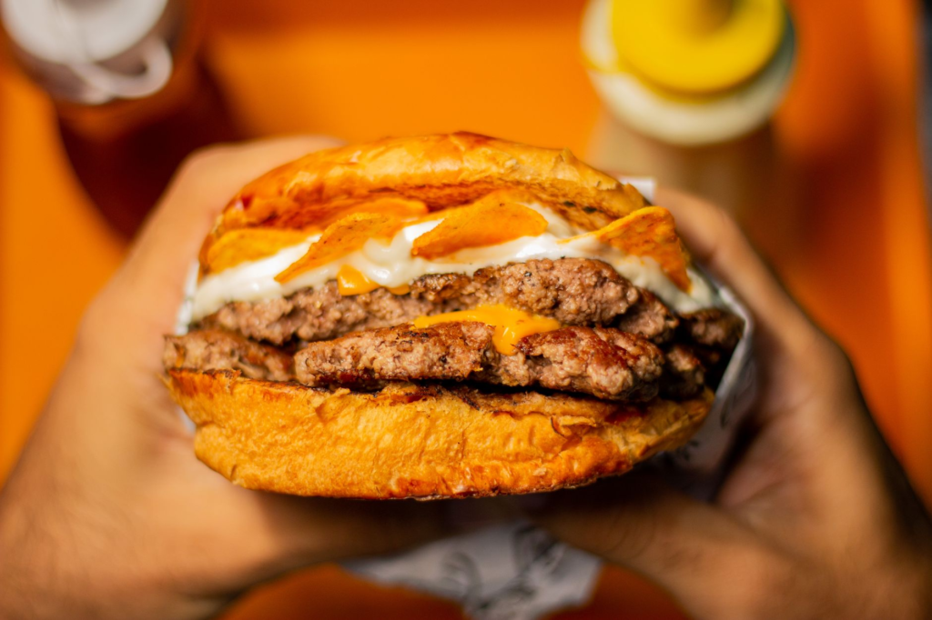 A vibrant close-up of the Craziness Burger, showcasing its colorful toppings and sauces. — Instagrammable burgers Las Vegas