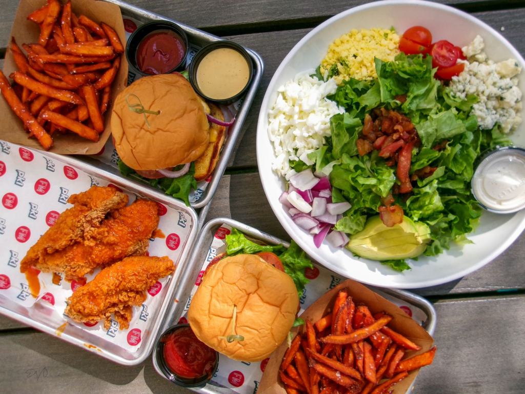 A vibrant plant-based burger served with fresh vegetables and a side of sweet potato fries. — plant-based burgers Las Vegas