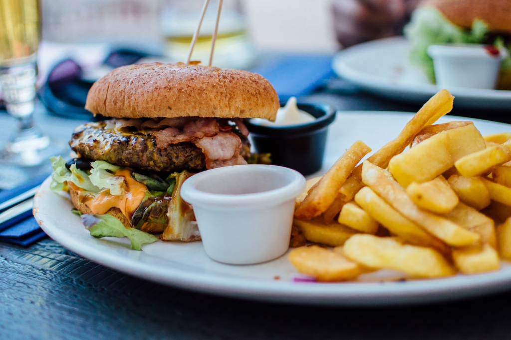 A vibrant plate featuring the Beyond Burger with fresh toppings and a side of sweet potato fries at a popular restaurant i…