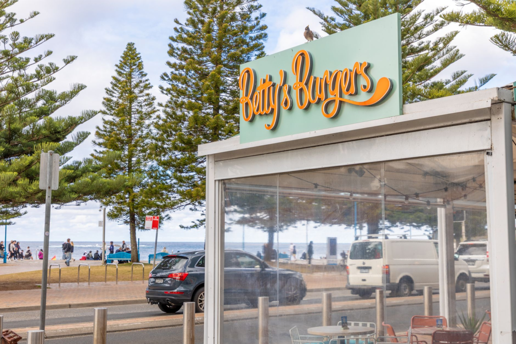 A vibrant street scene showcasing a popular burger joint with locals enjoying their meals outside. — local best burgers …