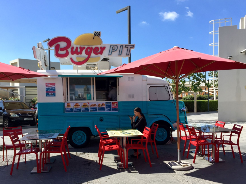 An outdoor seating area at a trendy burger place, perfect for enjoying quick burgers in the sunshine. — fast casual burg…