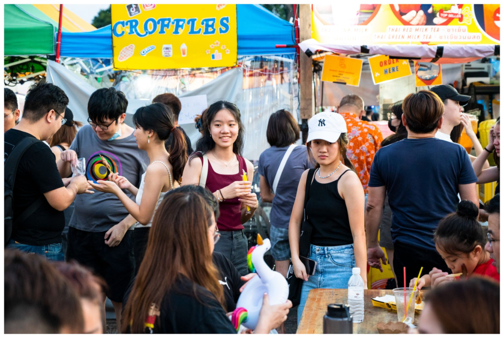 A bustling scene from a burger festival in Las Vegas with food stalls and happy attendees enjoying their meals. — burger…