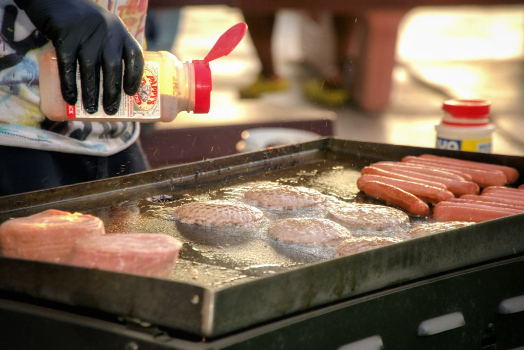 A chef grilling burgers at a festival, emphasizing the culinary talent involved in burger tasting events. — burger festi…