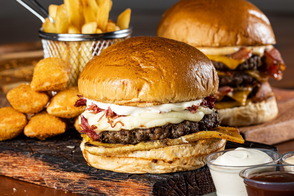 A close-up of a gourmet burger with trendy toppings and sides. — las vegas burger statistics
