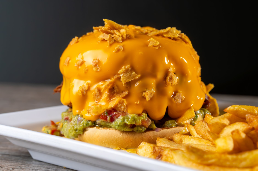 A close-up of a gourmet burger with unique toppings like avocado and fried egg. — burger toppings Las Vegas