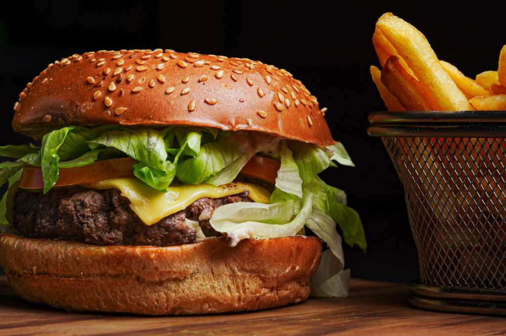 A close-up of a gourmet hamburger with fresh toppings and a side of fries. — best burger ranking criteria